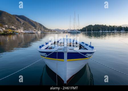 Una piccola barca di legno dipinta di fresco a Nydri alla luce del mattino. Uso da parte della gente del posto per la pesca sostenibile. Foto Stock