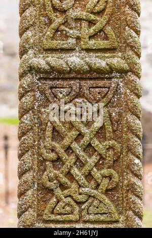 Dettagli del nodo celtico scolpiti in pietra su una croce celtica nella vecchia chiesa di Johnstown, County Kildare, Irlanda Foto Stock