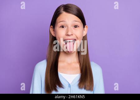 Foto di bruna bella ragazza piccola lingua fuori indossare camicia blu isolato su sfondo viola colore Foto Stock