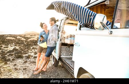 Giovane coppia di hipster al momento di relax insieme da mini van oldtimer - viaggio stile di vita concetto con indie persone in viaggio avventura minivan divertirsi Foto Stock