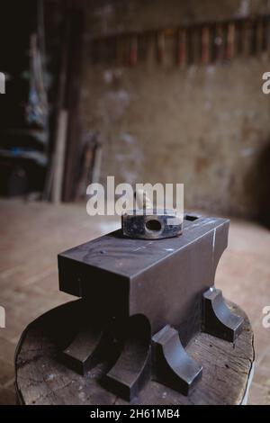 Martello con manico in legno mantenuto sull'incudine nell'industria manifatturiera Foto Stock