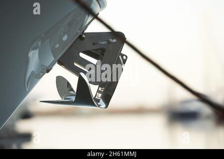 Vista ravvicinata dell'ancora dello yacht sulla parte anteriore di una barca di lusso. Barca a vela prua parcheggiata in porto, vela, vela Foto Stock