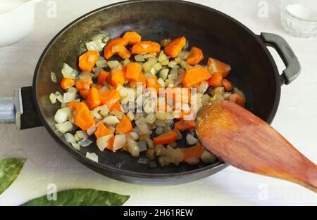 Ingredienti per la preparazione della zuppa di pesce. Cipolle e carote vengono fritte in un po' d'olio in una padella. Lohikeitto è un tradizionale finlandese e Karelian SO Foto Stock