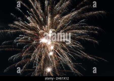 Un luminoso e colorato fuochi d'artificio riempie il cielo notturno sopra gli spettatori abbagliati nella contea di Macomb, Michigan USA. Foto Stock