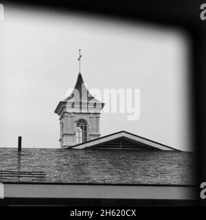 Basso angolo scala di grigi scatto di una chiesa con una croce sulla parte superiore Foto Stock