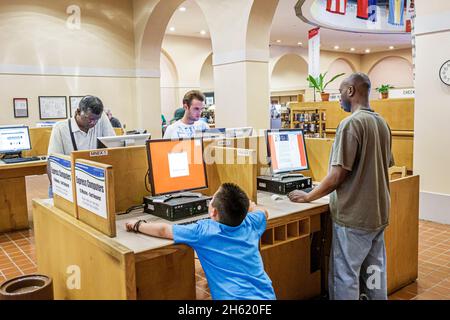 Miami Florida, Miami-Dade Public Library, interno computer station accesso a Internet, uomo nero ragazzo ispanico maschio Foto Stock