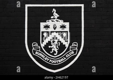 Badge Burnley FC dipinto di bianco sulla parete nera, Burnley Foto Stock