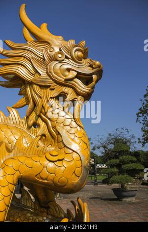 Statua del drago d'oro nel parco all'aperto in giornata di sole nella città di Hue, Vietnam Foto Stock