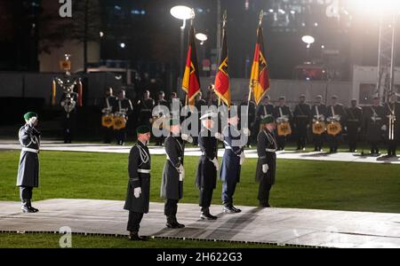 Berlino, Germania. 12 novembre 2021. I portieri di bandiera si levano in piedi alla promessa cerimoniale di circa 400 reclute del Bundeswehr sulla Piazza della Repubblica di fronte al palazzo del Reichstag. Di fronte agli ospiti della politica e della società, i soldati si impegnano a "servire fedelmente la Repubblica federale di Germania e a difendere coraggiosamente la legge e la libertà del popolo tedesco”. Con questa cerimonia annuale il giorno della fondazione della Bundeswehr, la Bundeswehr vuole dimostrare la sua comprensione della tradizione. Credit: Bernd von Jutrczenka/dpa/Alamy Live News Foto Stock