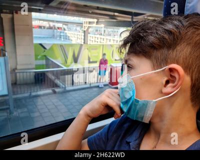 ragazzo con maschera sul treno Foto Stock