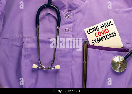 COVID-19 simbolo dei sintomi del codice a lunga distanza. Carta bianca con parole sintomi covidi a lungo raggio. Uniforme medica, penna metallica e stetoscopio. Medico, COVID Foto Stock