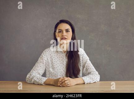 Ritratto di una donna seduta alla scrivania. Foto Stock