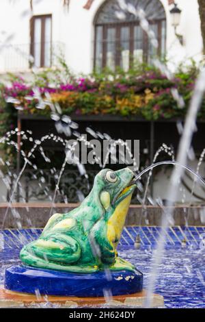 La statua di rana verde sputò l'acqua nella fontana di Vejer piazza bianca della città, Andalusia Foto Stock