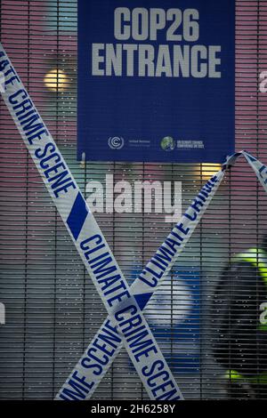 Glasgow, Scozia, Regno Unito. I poliziotti si schierano accanto al nastro che recita “Climate Crime Scene”, legato alla recinzione dei manifestanti climatici, al recinto di sicurezza fuori della sede della Conferenza delle Nazioni Unite sul cambiamento climatico COP26, mentre la conferenza e le riunioni si concludono all’interno di Glasgow, Scozia, il 12 novembre 2021. Foto: Jeremy Sutton-Hibbert/ Alamy Live News. Foto Stock