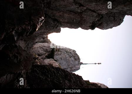 vista sulla croce della vetta durante un'escursione fino alla cima del kampenwand (1669 m) nel chiemgau, alpi chiemgau, vicino aschau, alta baviera, baviera, germania meridionale, germania Foto Stock