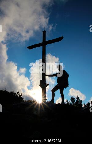 uomo vecchio alla croce di cima, escursione al gap 1829m, estergebirge, tramonto, luce posteriore, tenendo croce, europa, germania, baviera, alta baviera, werdenfelser terra, alpenwelt karwendel, isar valle, krün Foto Stock