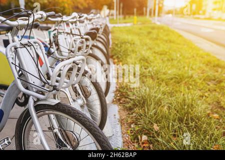 Biciclette da città a noleggio. Noleggio biciclette pubbliche parcheggiate in primo piano. Stile di vita urbano. Messa a fuoco selettiva, spazio di copia. Foto Stock