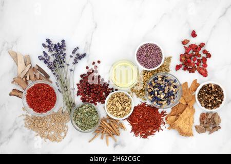 Raccolta di erbe e fiori utilizzati in medicina vegetale. Concetto di assistenza sanitaria alternativa per la guarigione naturale. Vista dall'alto, piatto su sfondo di marmo Foto Stock