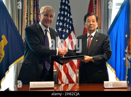 Il Segretario della Difesa Chuck Hagel scrolla le mani con il Ministro della Difesa Nazionale sudcoreano Han min-koo dopo la firma di un memorandum d'intesa il 23 ottobre 2014. Foto Stock