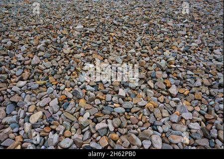 Riassunto di grandi ciottoli multicolore e testurizzati su una spiaggia Foto Stock