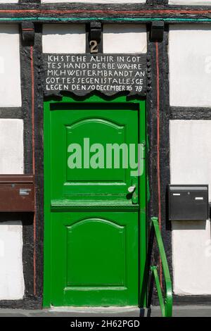 germania,wuelfrath,bergisches terra,niederbergisches terra,niederberg,renania,renania settentrionale-vestfalia,città vecchia,edificio residenziale a kirchplatz 2,casa a graticcio,scultura in legno,benedizione su un bar sopra la porta d'ingresso Foto Stock