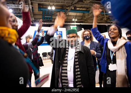 Glasgow, Regno Unito. 12 novembre 2021. Glasgow, Scozia, Regno Unito. 12 novembre 2021PICTURED: Una festa si apre con tutti i tipi di musica da tutto il mondo, con i delegati COP26 che si srotolare in mosse di danza e lanciare forme su quella che era la sala della conferenza, la gente, Ridere e lasciare i capelli giù e giocare una partita di limbo sotto una tenda arrotolata l'ultimo giorno della COP26 Climate Change Conference. Credit: Colin Fisher/Alamy Live News Foto Stock