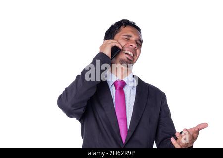 L'uomo d'affari ride mentre parla al telefono. Giovane adulto che utilizza uno smartphone. Concetto di espressione di un imprenditore. Persona che utilizza la tecnologia Foto Stock