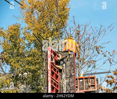 Dnepropetrovsk, Ucraina - 10.22.2021: Costruttore installa casseforme e rinforzi in ferro o barre di rinforzo per pareti divisorie in cemento armato. Costruzione Foto Stock