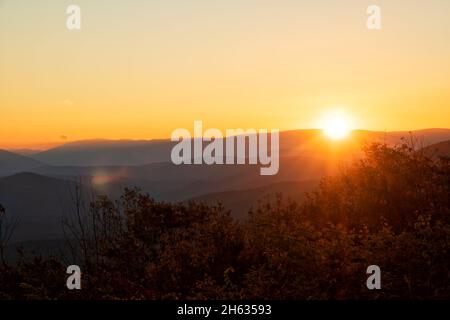 Sole che arriva sulla cima della montagna al mattino presto nella foresta nazionale di Ouachita, con razzi e raggi Foto Stock