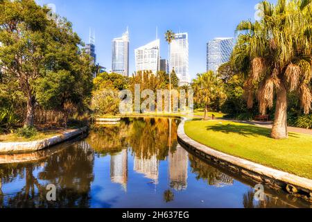 Il CBD di Sydney è un'alta torre con alberi verdi e laghetto d'acqua nel parco pubblico della città in una giornata estiva soleggiata. Foto Stock