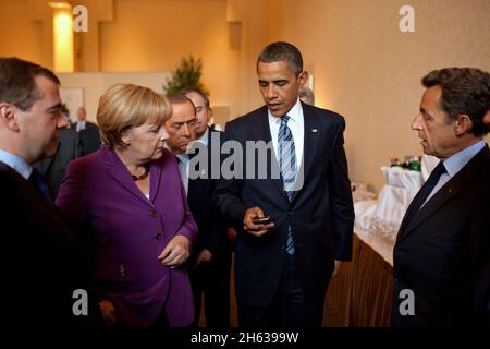 Il presidente Barack Obama mostra la sua BlackBerry al presidente russo Dmitry Medvedev, alla cancelliera tedesca Angela Merkel, al primo ministro italiano Silvio Berlusconi e al presidente francese Nicolas Sarkozy, prima di un incontro con i leader africani dell’Outreach al G8 tenutosi a Muskoka, Canada, il 25 giugno 2010. Foto Stock