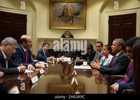 Il presidente Barack Obama cade dall'incontro del consigliere per la sicurezza nazionale Susan E. Rice con il presidente della coalizione di opposizione siriana Ahmad Jamba, secondo da sinistra, nella stanza Roosevelt della Casa Bianca, 13 maggio 2014. Foto Stock