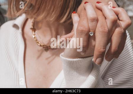 giovane coppia a scatto di fidanzamento,mani di tenuta,anello di fidanzamento,donna bionda Foto Stock