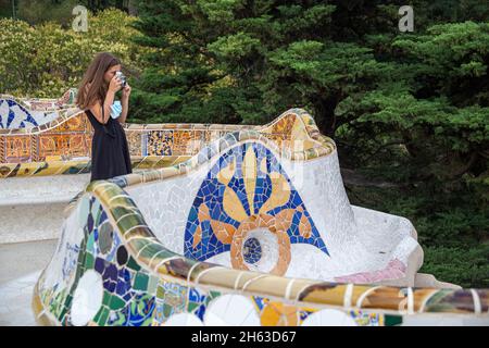 i colorati posti a sedere a mosaico sono disegnati da gaudi. i colori vivaci delle piastrelle sono mozzafiato. parco artistico di antoni gaudi guell a barcellona, spagna. questo parco modernista è stato costruito tra il 1900 e il 1914 ed è una popolare attrazione turistica. Foto Stock