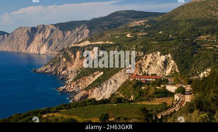 grecia,isole greche,isole ionie,cefalonia,penisola di paliki,costa occidentale,luce serale,monastero di kipoureon,tramonto,barca a vela,luna piena,costa rocciosa,monastero di kipoureon con un tetto rosso è solitario sopra la costa rocciosa nel paesaggio,sullo sfondo ancora più aspro, ripidi costa rocciosa Foto Stock