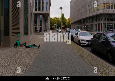 germania, berlino, parcheggiato e ribaltato senza sosta e-scooters in una strada laterale non lontano dalla stazione ferroviaria principale di berlino la mattina presto Foto Stock