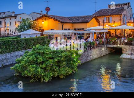 terrazza ristorante sul fiume mincio al tramonto,borghetto,frazione valeggio sul mincio,borgo mulino,pianura padana,provincia di verona,veneto,italia Foto Stock