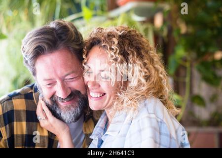 felice e allegro adulto caucasico coppia ritratto sorriso e godere l'amore e la relazione insieme - uomo con barba e donna con capelli biondi lungo ricci in tenerezza sensazione di attività Foto Stock