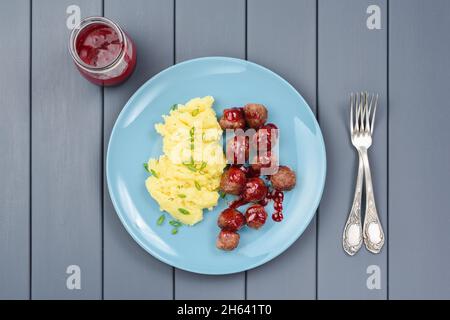 Polpette svedesi e purè di patate con salsa di mirtilli sul piatto blu sopra la vista Foto Stock