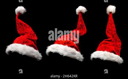 cappelli di natale rossi isolati su sfondo nero Foto Stock