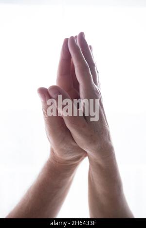 palma di mani umane unite in posizione di preghiera namaste su sfondo bianco dello spazio di copia. concetto di benessere e stile di vita sano. mani adulte che fanno meditazione yoga in posa di preghiera. Foto Stock