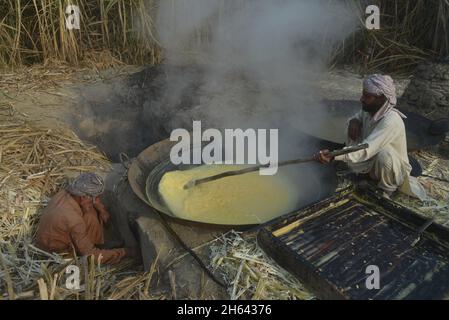 Lahore, Pakistan. 11 Nov 2021. Gli agricoltori pakistani sono impegnati a fare la tradizionale jaggery (Gur) a Sugar cane Field, nella zona delle baraccopoli della capitale provinciale Lahore. (Foto di Rana Sajid Hussain/Pacific Press) Credit: Pacific Press Media Production Corp./Alamy Live News Foto Stock