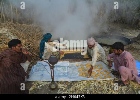 Lahore, Punjab, Pakistan. 11 Nov 2021. Gli agricoltori pakistani sono impegnati a fare la tradizionale jaggery (Gur) a Sugar cane Field, nella zona delle baraccopoli della capitale provinciale Lahore. (Credit Image: © Rana Sajid Hussain/Pacific Press via ZUMA Press Wire) Foto Stock