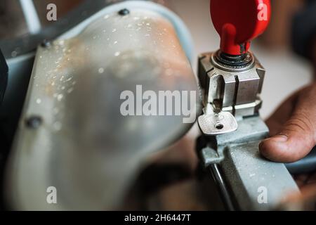 Chiudere la vista della macchina copiatrice con chiave. Duplicare la macchina per creare una nuova chiave. Tema fabbro. Chiavi vuote per il taglio. Apriporta auto moderna nera. Foto Stock