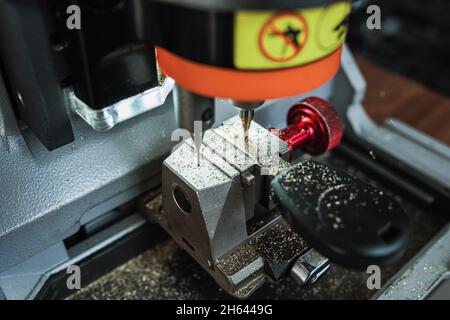 Chiudere la vista della macchina copiatrice con chiave. Duplicare la macchina per creare una nuova chiave. Tema fabbro. Chiavi vuote per il taglio. Apriporta auto moderna nera. Foto Stock