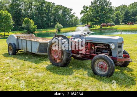 Un trattore agricolo Massey Ferguson 35 di colore rosso e grigio antico con spanditore per liquame è in mostra in occasione di una mostra di trattori a Warren, Indiana, USA. Foto Stock