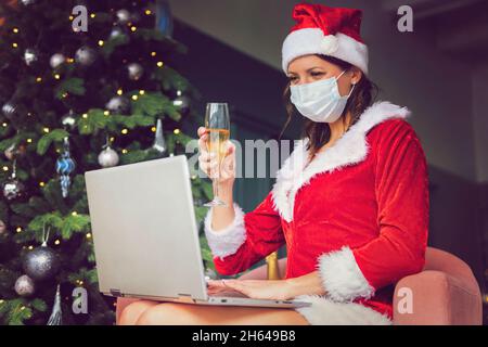 Closdup bella donna asiatica cappello e rosso Babbo Natale sorridente felicemente, champagne vetro, concept vacanza festeggiamento, albero di Natale sfondo. Cristo Foto Stock