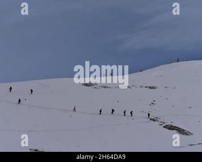 Silhouette di persone che seguono le impronte nella neve sulla cima di Edith Cavell Meadows Trail nel Jasper National Park, Alberta, Canada. Foto Stock