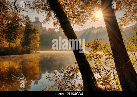 Bellissimo paesaggio autunnale alba del castello di Trakošćan sulla collina da riflesso nel lago in Croazia, contea hrvatsko zagorje Foto Stock