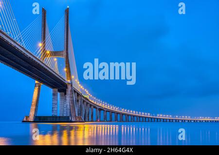 Il ponte Vasco da Gama sul fiume Tago a Lisbona, Portogallo, al crepuscolo Foto Stock